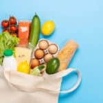 Shopping bag full of healthy food on blue