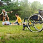 Disabled man lifting up his daughter on picnic